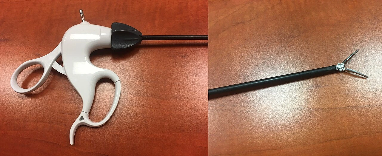 A ring-handled instrument with a long insulated shaft and small curved jaws; an inset shows the jaws.