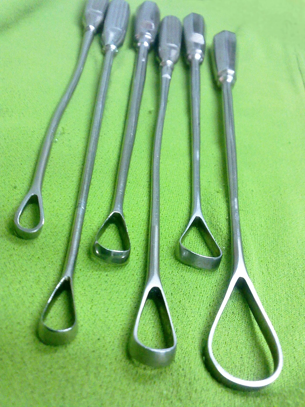 Several long-handled metal tools have open oval or triangular loops in graduated sizes.
